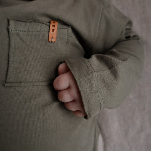 Longsleeve wild green voor baby's (kinderen) met een zakje aan de voorzijde van het merk Nixnut.