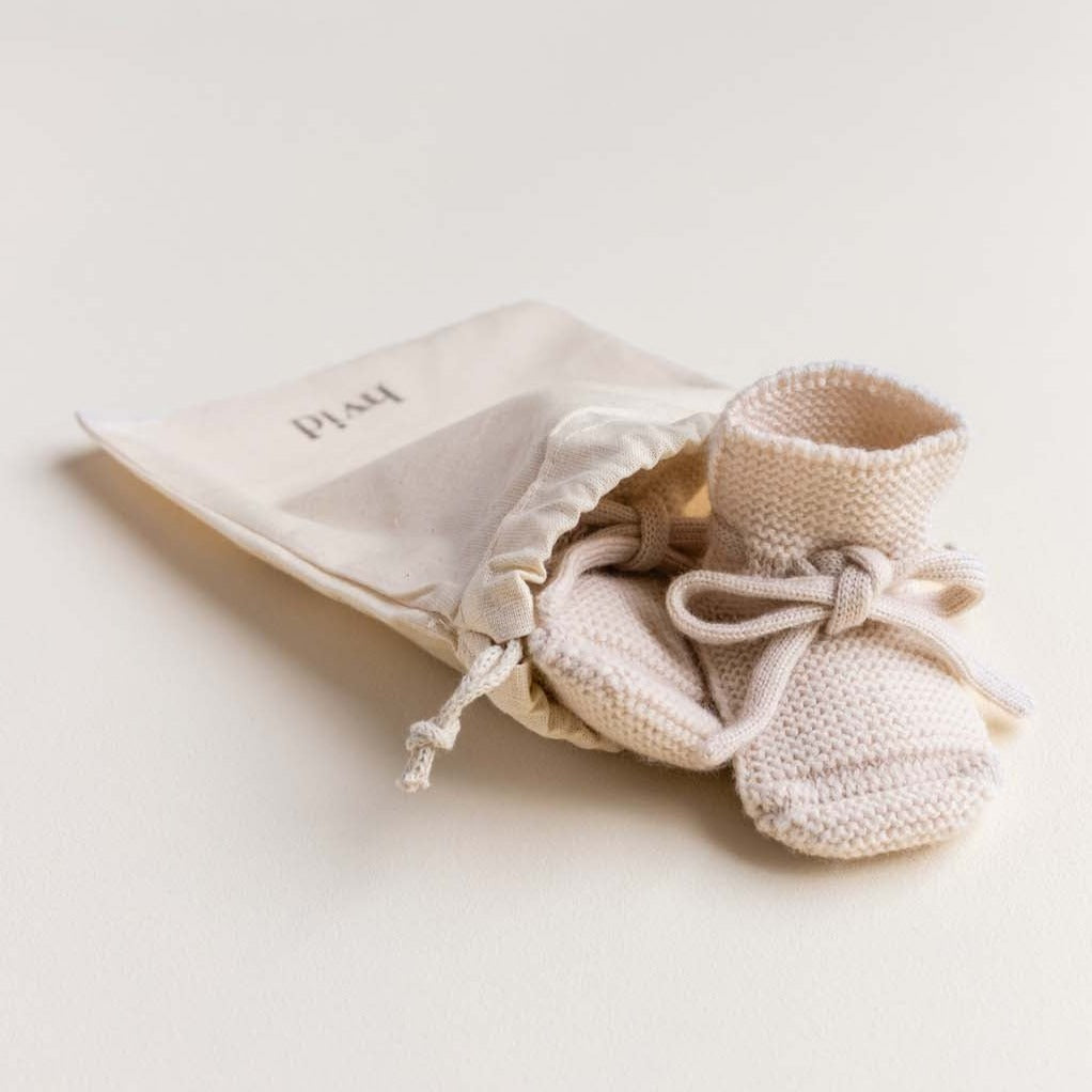 Booties cream van het merk hvid in een zakje.