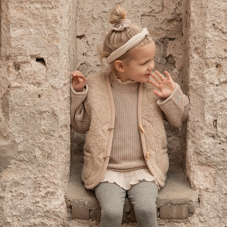 Kind draagt beige wollen bodywarmer van het merk Alwero lifestyle 1.