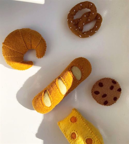 Habdgemaakte vilten broodset met een croissant, pretzel, koekje en kaas voor kinderen om mee te spelen