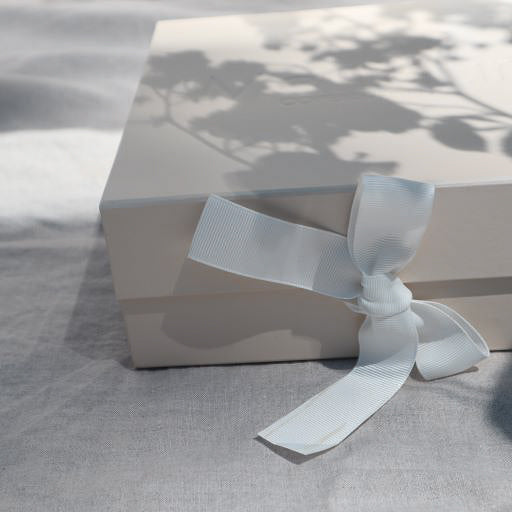 Geschenkbox met daarin een newborn setje bestaande uit een body en broek met voetjes van Mar Mar Copenhagen.