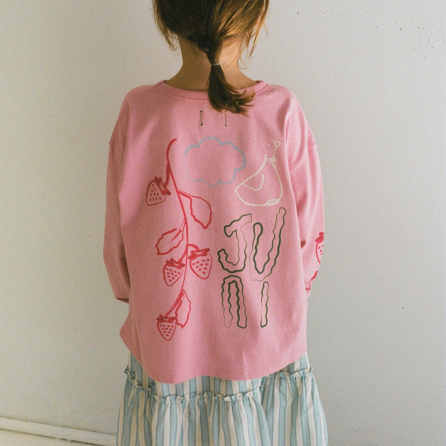 Roze longsleeve top van het merk juni achterkant bij een meisje aan