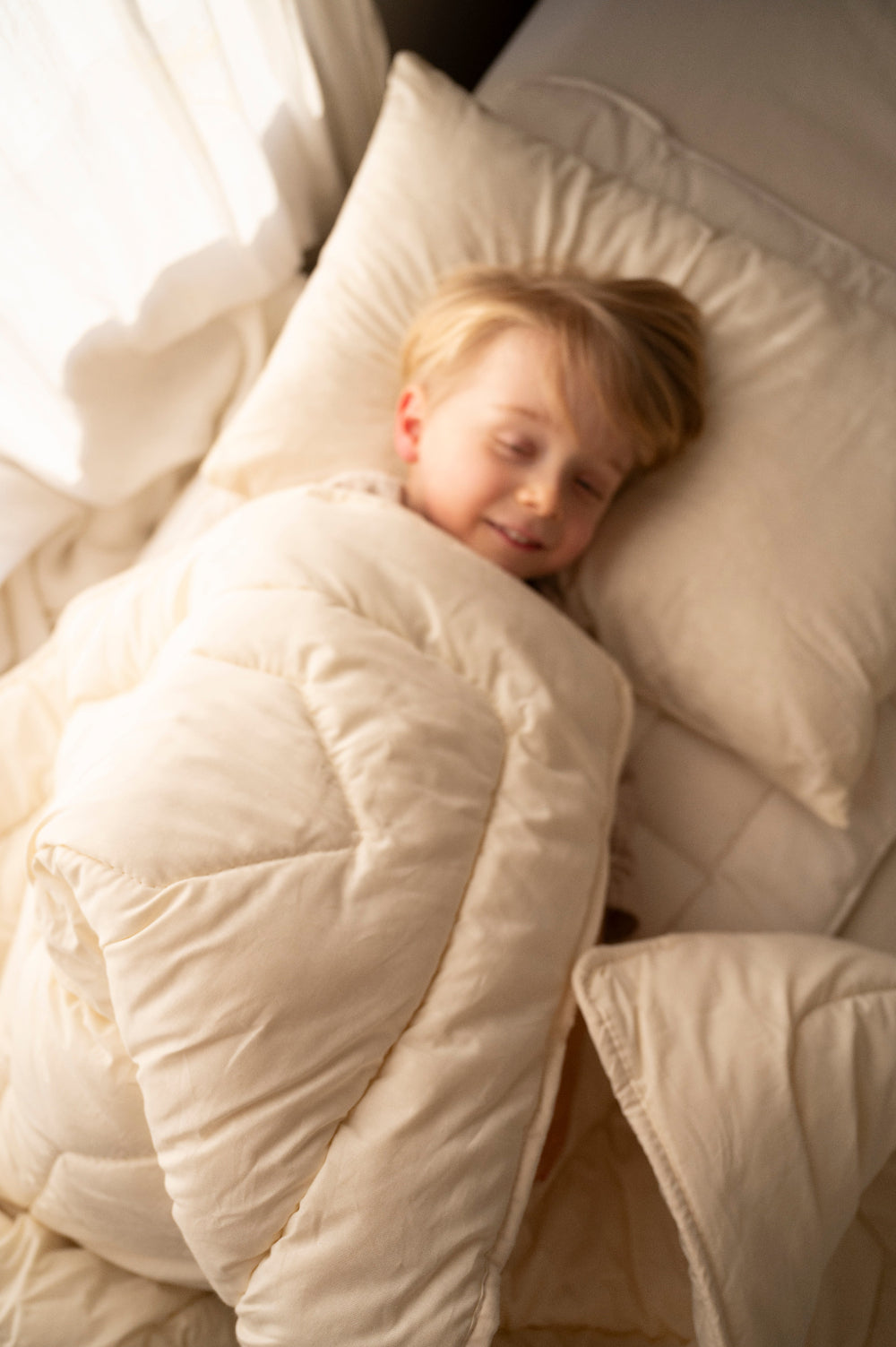 Kind dat slaapt onder dekbed