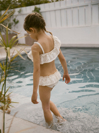 Meisje met witte one shoulder bikini aan