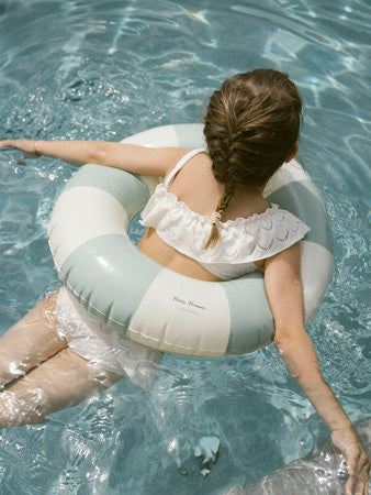 Meisje in zwemband met witte bikini