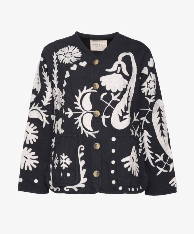 Maggie Suzani Jacket heeft een casual fit met twee zakken aan de voorkant. Het jasje is gemaakt van katoenen canvas. Je ziet over het gehele jasje een opvallende Suzani borduurwerk met klaproosbloemen, harten en een prachtige Indiase pauw aan de achterkant. Het borduurwerk is handgemaakt. De naam 'Suzani' komt van het Perzische woord 'su-zan' wat naald betekent.