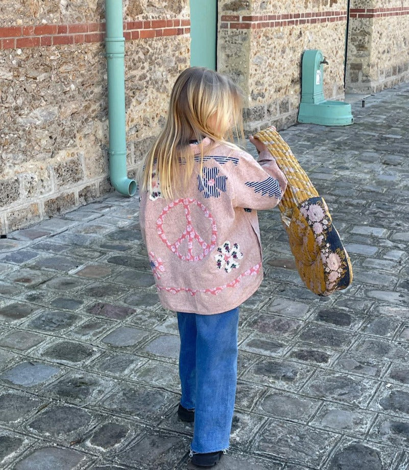 Peach mini patchwork jacket is een populair item uit de collectie van Sissel Eldelbo. De jas heeft een kleine kraag en is gemaakt met zakken aan de voorkant. De jas is gemaakt van 100% katoen met patchwork van een blokprint. Het handgemaakt patchwork is voorzien van een vredesteken en bloemendecoratie. Alle randen zijn mooi bedekt met katoenen randen.