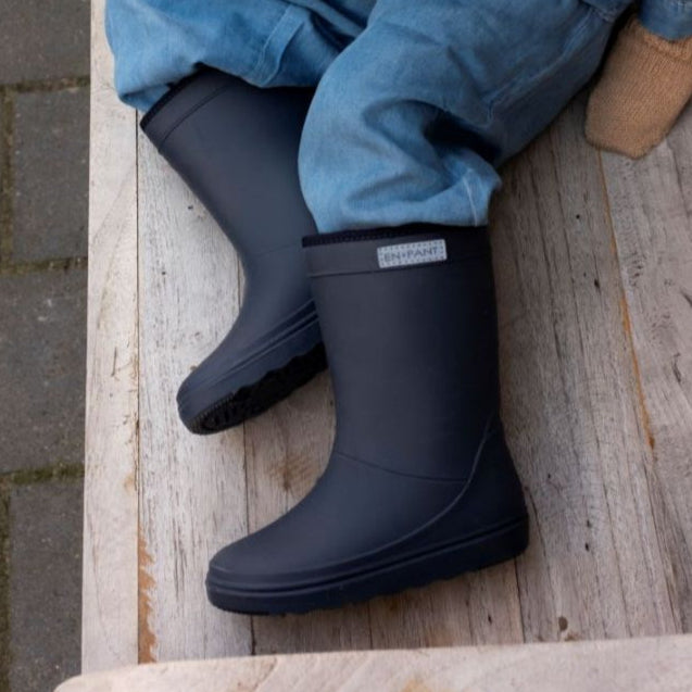 Blauwe thermoboots van het merk Enfant aan bij een kindje die op de tafel ligt