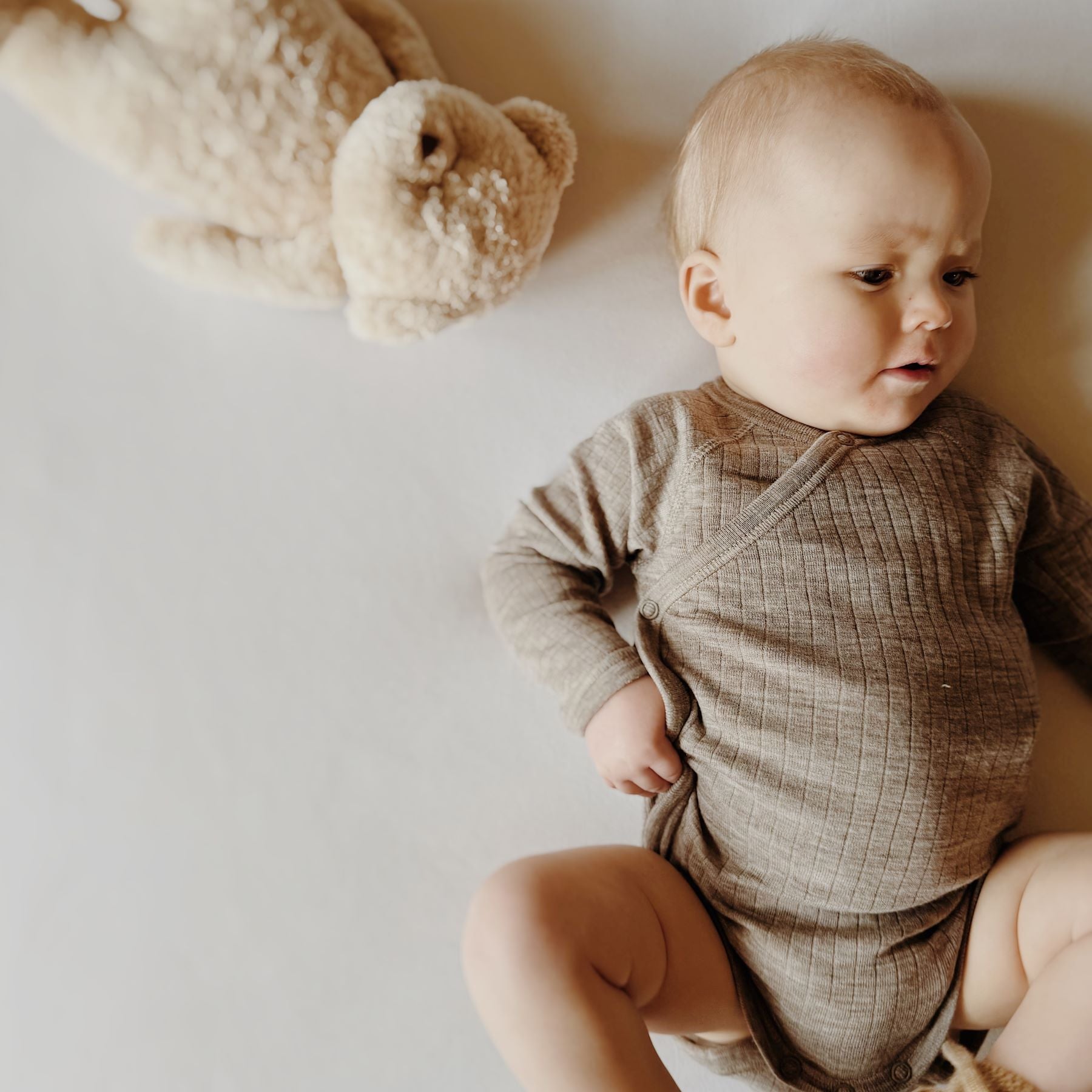 Wikkelromper Merino Wol Sesam Joha lifestyle baby aan de zijkant.