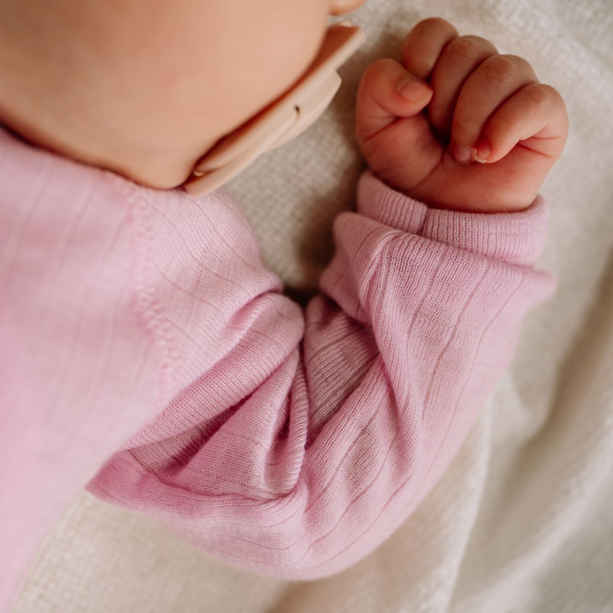 Wikkelromper merino wol rose close up handje