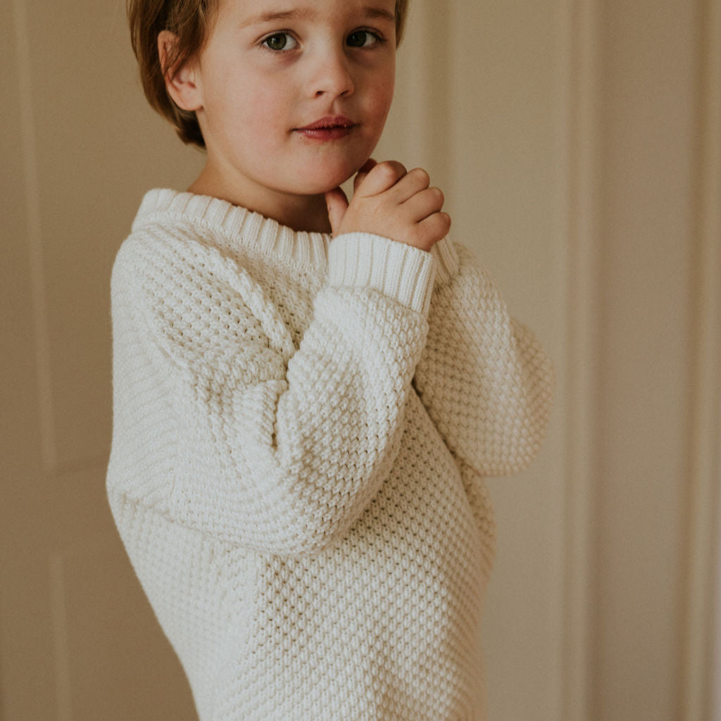 Jongen met gebreide witte trui van Yuki aan