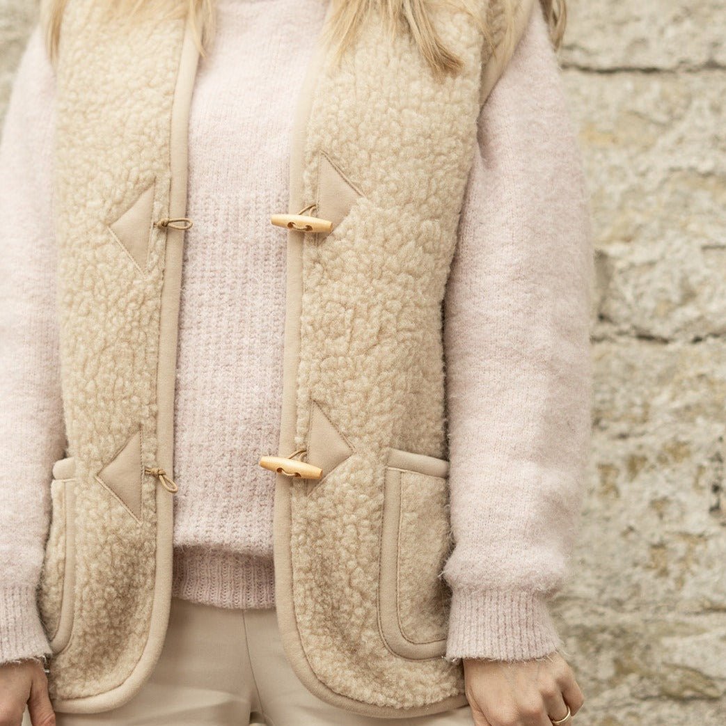 Model heeft de ADULT Bodywarmer All Beige van Alwero aan close up.