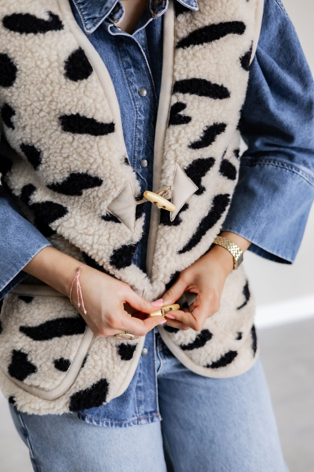 Bodywarmer met koeienprint aan bij iemand met spijkervest