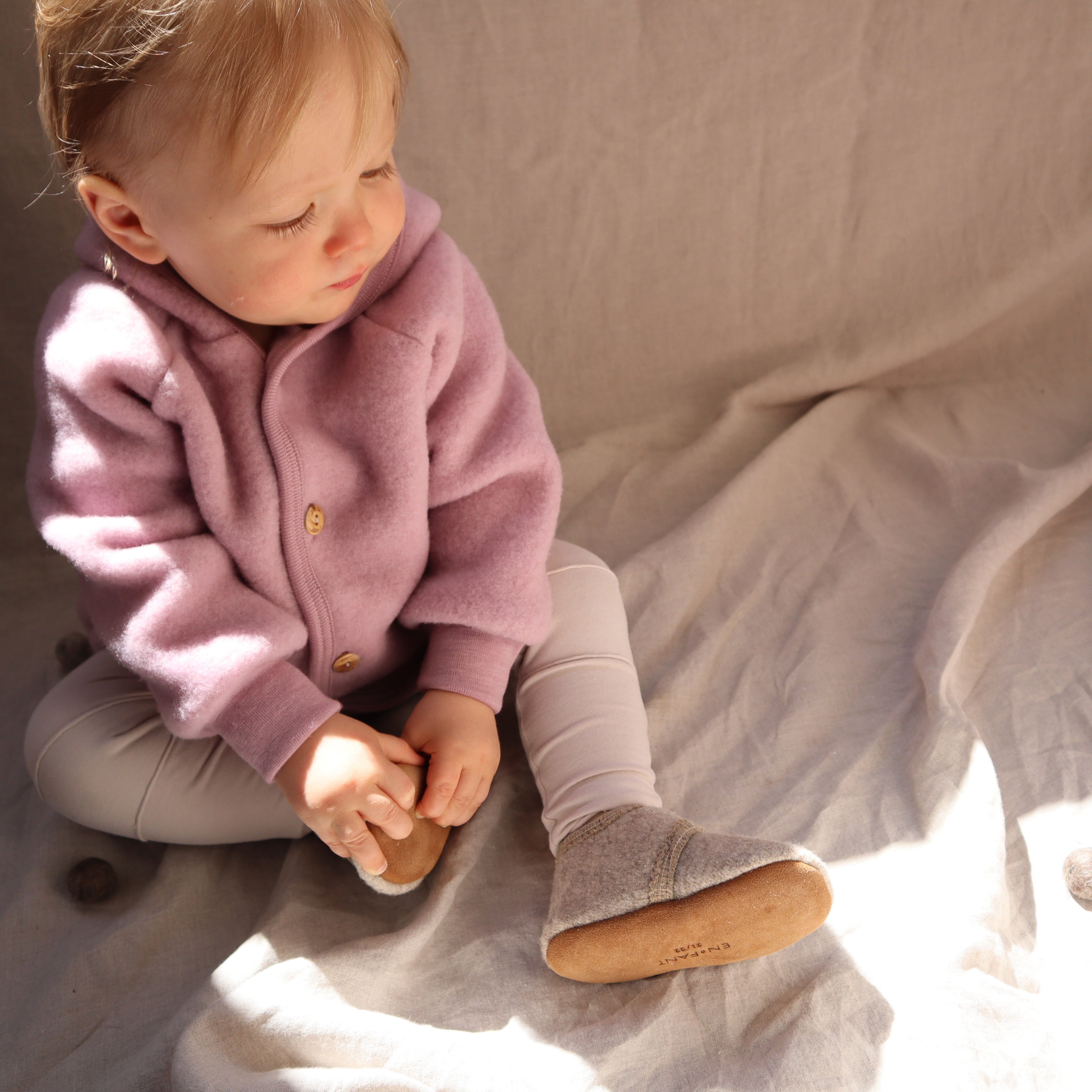Babyslofjes wool sand melange in combinatie met Engel Natur jasje lifestyle.