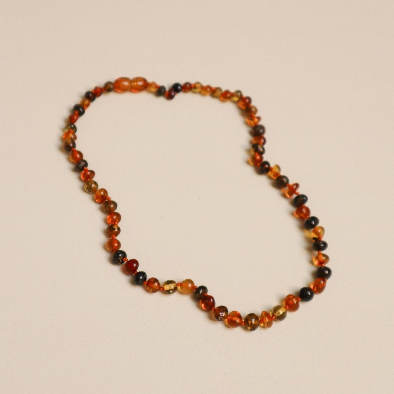 Barnsteen ketting mix met beige achtergrond