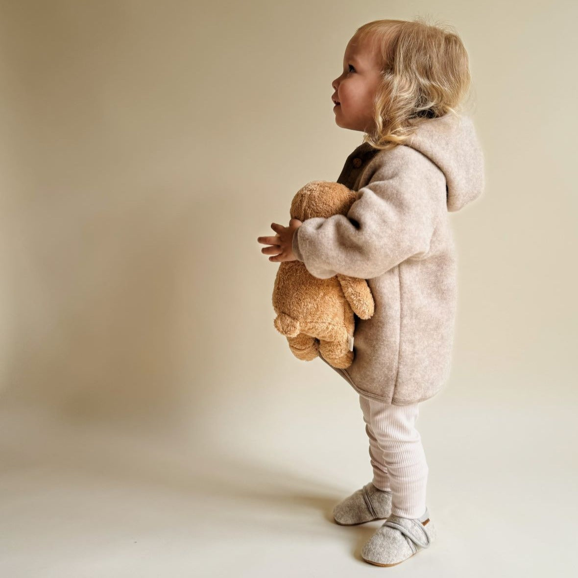 De slaapknuffel van Moonie in de vorm van een beer in de kleur cappuccino voor baby's die rustgevende geluiden maakt die de slaap bevorderen voorzijde. 