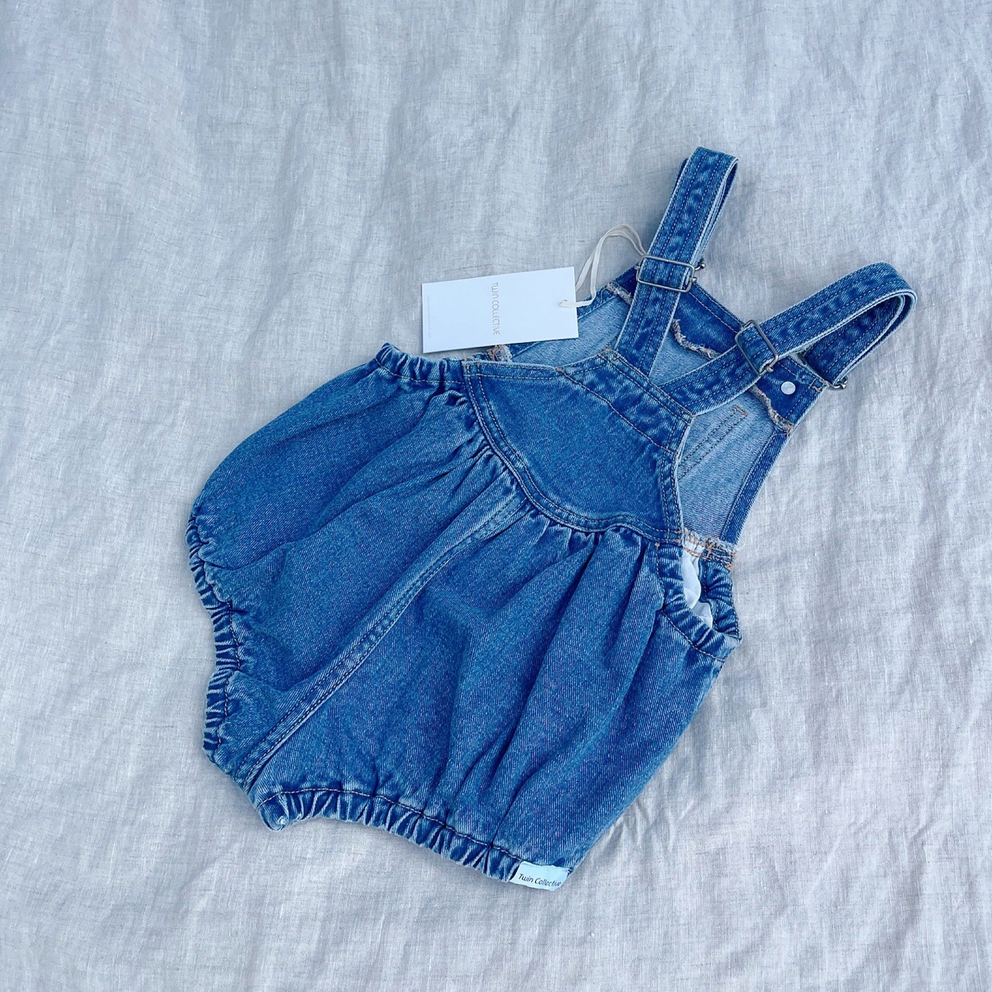 Baby overall (spijkerpakje) van spijker zonder mouwen van Twin Collective.