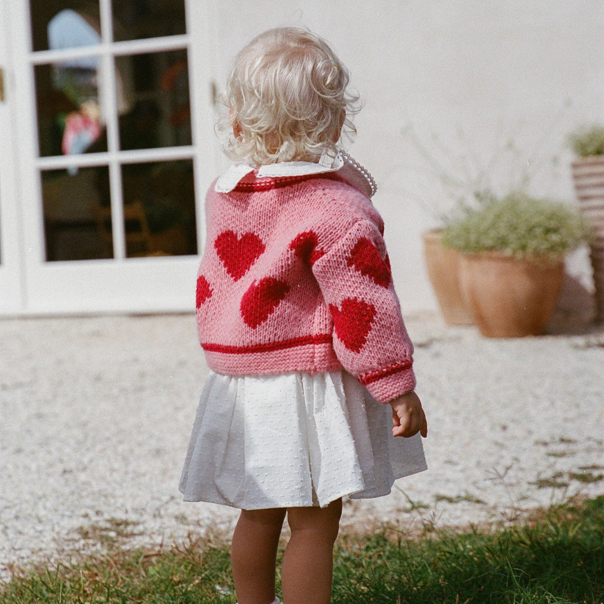 Love cardigan thewholesomestore achterkant aan bij meisje