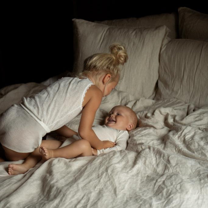 Kinderen met pyjama aan op bed