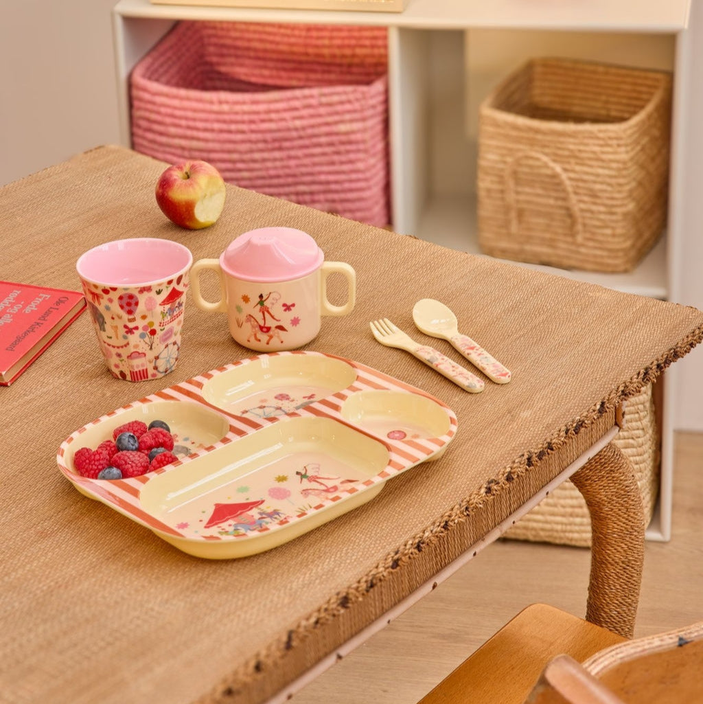 Roze beker voor kinderen met circus figuurtjes erop op tafel