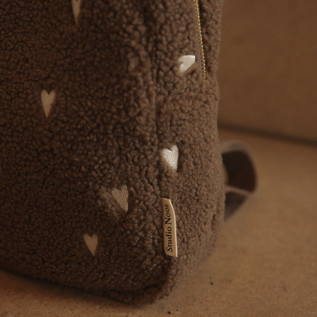 Bruine rugzak teddy stof met witte hartjes dichtbij