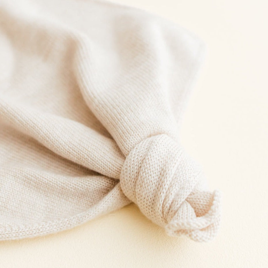 Gebreid speendoekje voor baby's in de kleur Cream van HVID. Gebreid speendoekje voor baby's in de kleur cream van HVID ingezoomd op knoop. 