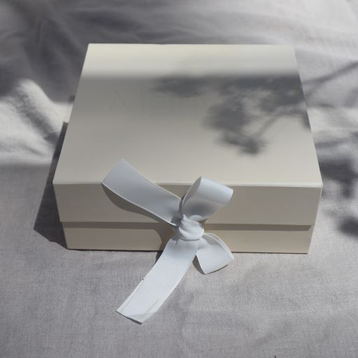 Geschenkbox met daarin een newborn setje bestaande uit een body en broek met voetjes van Mar Mar Copenhagen.