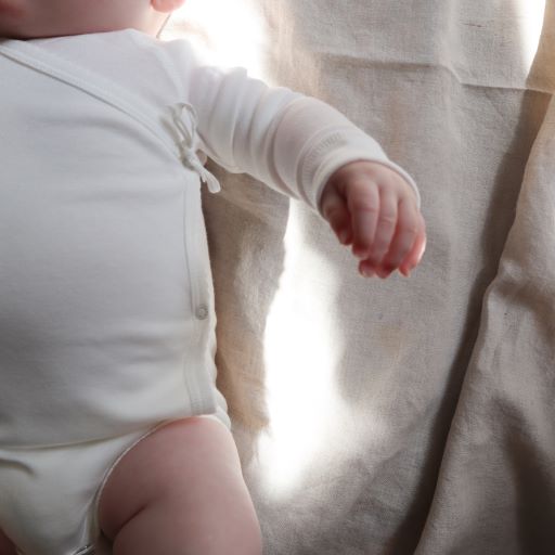 Overslagromper voor baby's in Gentle White (naturel) met een strikje als afwerking van Mar Mar Copenhagen.