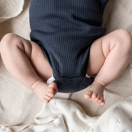Overslagromper voor baby's in donkerblauw met een strikje als afwerking van Mar Mar Copenhagen.