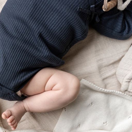 Overslagromper voor baby's in donkerblauw met een strikje als afwerking van Mar Mar Copenhagen.